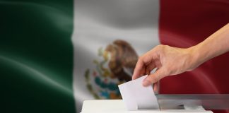 Urnas y boletas electorales con mapa de Yucatán de fondo.